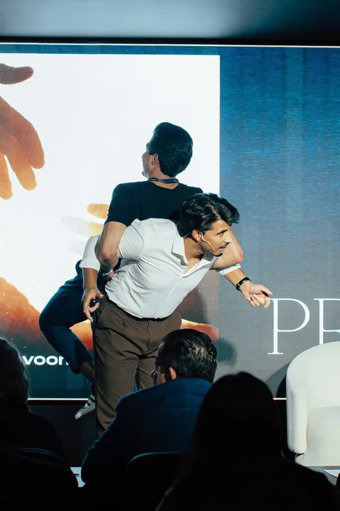 Abraço entre dois homens no palco do evento