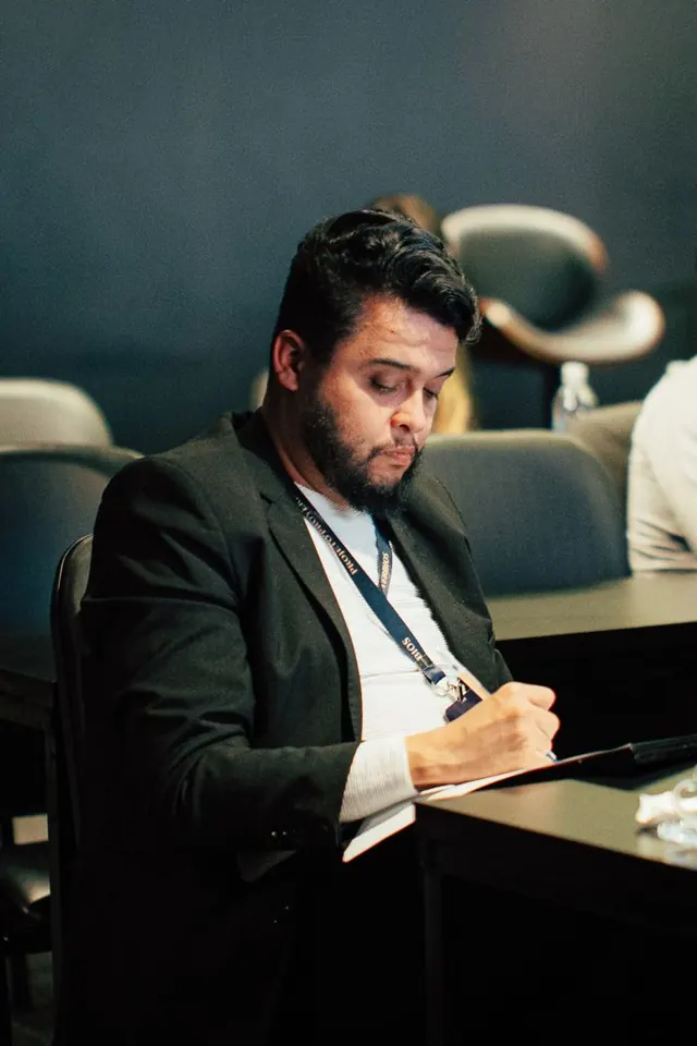 Empresário anotando com crachá no pescoço