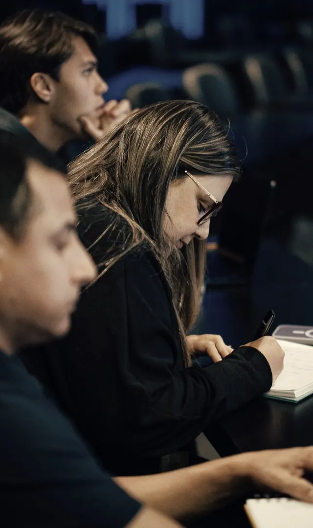 Participantes escrevendo em cadernos durante o encontro